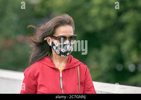 LONDON, GROSSBRITANNIEN. 17. Juli 2020. Fußgänger mit Schutzmaskenschutz gegen COVID-19 Infektionen mit floralen Mustern. Kredit: amer ghazzal/Alamy Live Nachrichten Stockfoto