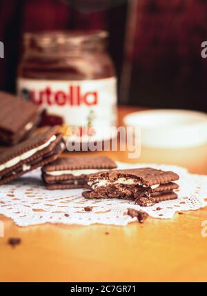 Vertikale selektive Fokusaufnahme von halbgefressenen Schokoladenkeksen mit Nutella In einem verschwommenen Hintergrund Stockfoto