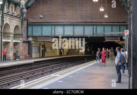 London, Großbritannien. 17. Juli 2020. Viele Linien und Stationen bleiben ruhig, wie wenige Touristen besuchen London und viele Büroangestellte Home-working oder auf Furlough trotz Coronavirus Lockdown Lockerung. Bild: Maskierte Reisende an der Notting Hill Gate Station auf der District und Circle Linie. Quelle: Malcolm Park/Alamy Live News. Stockfoto