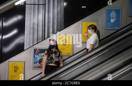 London, Großbritannien. 17. Juli 2020. Viele Linien und Stationen bleiben ruhig, wie wenige Touristen besuchen London und viele Büroangestellte Home-working oder auf Furlough trotz Coronavirus Lockdown Lockerung. Bild: Maskierte Reisende auf Rolltreppen am normalerweise geschäftigen Holborn Bahnhof. Quelle: Malcolm Park/Alamy Live News. Stockfoto