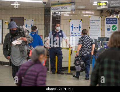 London, Großbritannien. 17. Juli 2020. Viele Linien und Stationen bleiben ruhig, wie wenige Touristen besuchen London und viele Büroangestellte Home-working oder auf Furlough trotz Coronavirus Lockdown Lockerung. Bild: Maskierte Bahnhofsmitarbeiter helfen den Reisenden am Notting Hill Gate Bahnhof. Quelle: Malcolm Park/Alamy Live News. Stockfoto