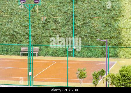 Orange Farbe Rasen Tennisplatz Teilansicht mit grünen Patch Wände Stockfoto