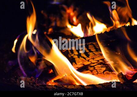 Nahaufnahme der Flammen eines Lagerfeuers mit einem verschwommenen Hintergrund während der Nacht Stockfoto