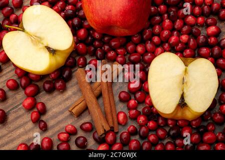 Weihnachten und Feiertage Rezepte, Glühwein Zutaten und saisonale Kochkonzept mit geschnittenen roten Äpfeln, Haufen von Preiselbeeren und Zimtstangen i Stockfoto