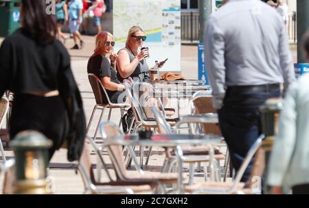 Bournemouth, Großbritannien. Juli 2020. Zwei Frauen genießen ihre Getränke in einem Café in Bournemouth Square, Dorset. Kredit: Richard Crease/Alamy Live Nachrichten Stockfoto