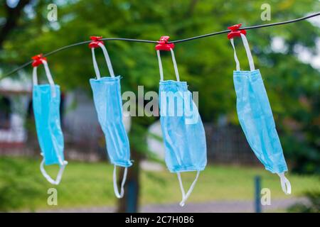 Selektive Fokussierung von Gesichtsmasken, die nach dem Waschen an einem Draht hängen. Stockfoto