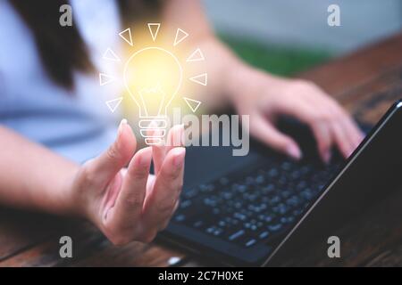 Junge Frau mit Glühbirne. Holen Sie sich Ideen, innovative Technik und Kreativitätskonzept Stockfoto