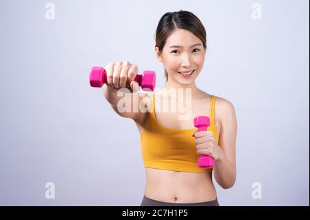 Asiatische sportliche Frau mit Hantel fit schlanken Körper isoliert auf weißem Hintergrund. Konzept der gesunden Lebensweise Stockfoto