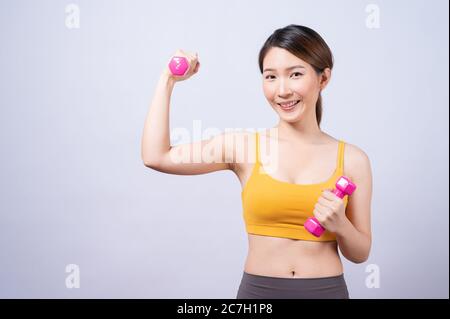 Asiatische sportliche Frau mit Hantel fit schlanken Körper isoliert auf weißem Hintergrund. Konzept der gesunden Lebensweise Stockfoto