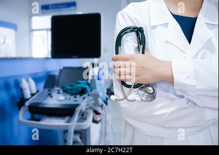 Frau Arzt hält Stethoskop auf Krankenhaushintergrund Stockfoto