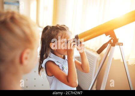 Zwei Schülerinnen schauen durch ein Teleskop in einer Astronomie-Lektion, zurück zur Schule, Kindererziehung Stockfoto