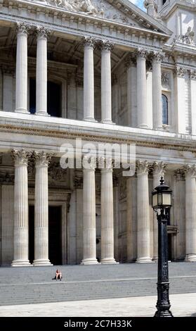 London, Großbritannien. Juli 2020. Ein warmer sonniger Nachmittag in London. Eine Frau sitzt allein auf den Stufen von St Paul's Credit: PjrFoto/Alamy Live News Stockfoto