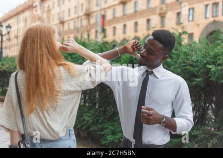 Ellenbogen Beule Gruß, um die Ausbreitung von Coronavirus zu vermeiden. Schwarzer Mann und kaukasische Frau verwenden Ellbogen statt Handflächen für die Begrüßung Stockfoto