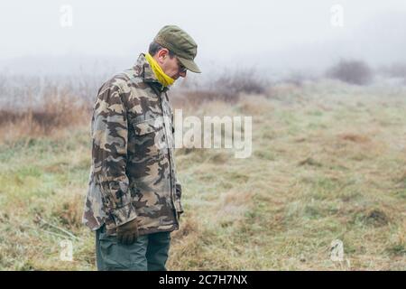 Soldat, der an Depressionen leidet und auf den Boden schaut Stockfoto