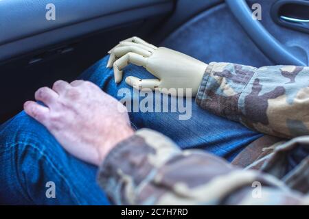 Soldat mit prothetischer Hand fährt im Auto Stockfoto