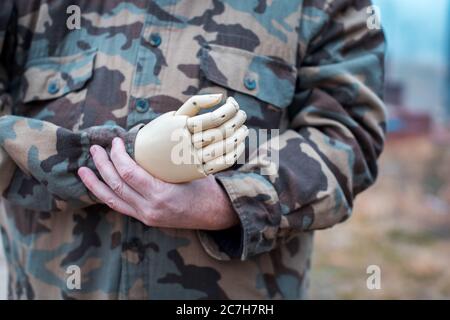 Soldat mit prothetischer Hand trägt ein Militär-Hemd Stockfoto