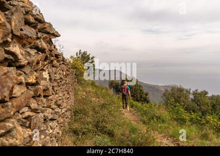 Europa, Spanien, Katalonien, Girona, Alt Empordà, Port de la Selva, Spaziergänger auf einem Küstenwanderweg nahe dem Kloster Sant Pere de Rodes mit Blick auf das Mittelmeer Stockfoto