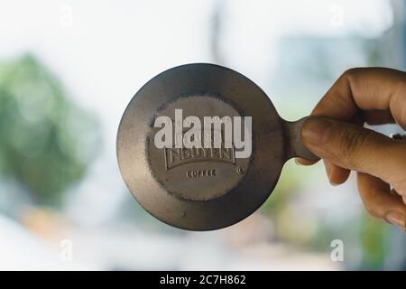 Pleiku Stadt, Vietnam - 12 Juli 2020: Nahaufnahme Hand hält Trung Nguyen Kaffee Deckel von vietnamesischen Phin Filter. Selektiver Fokus. Stockfoto