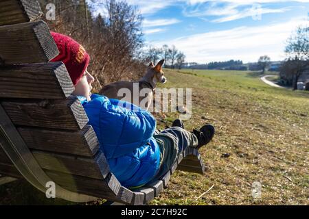 Europa, Deutschland, Baden-Württemberg, Schwäbische Alb, Albstadt, Junge und Hund sitzen auf einer Liege auf der Schwäbischen Alb Stockfoto