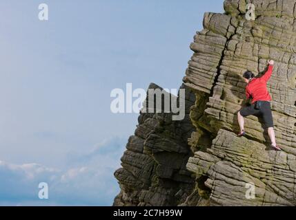 Frau klettert an den Windgather Felsen im British Peak District Stockfoto