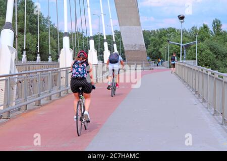 Radfahrer fahren Fahrräder auf der Brücke in Warschau. Menschen fahren Fahrräder in der polnischen Hauptstadt Warschau. Touristen reisen mit dem Fahrrad Stockfoto