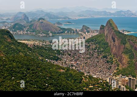 Rocinha Slum auf dem Berg in Rio de Janeiro und die Stadt dahinter Stockfoto