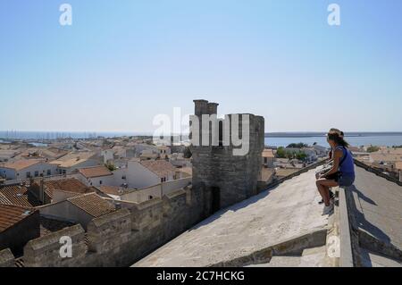 SAINTES-MARIES-DE-LA-MER, FRANKREICH - 06. Jun 2010: Eine Gruppe von Menschen, die auf einem Dach unter den Häusern in der Nähe des Ozeans sitzen, die in Camargue, Frankreich, gefangen genommen wurden Stockfoto