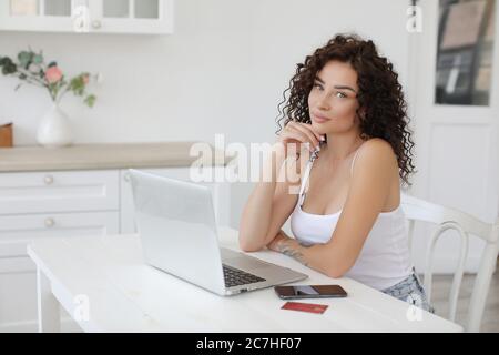 Porträt einer jungen Frau, die zu Hause mit einem Laptop arbeitet Stockfoto