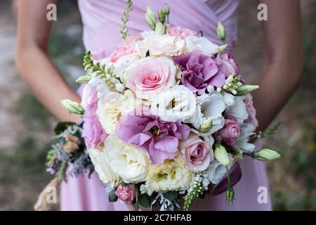 Brautstrauß von rosa und lila Blumen in den Händen eines Freundes Stockfoto