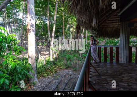 Amerika, Karibik, Großantillen, Dominikanische Republik, Cabarete, Frau blickt vom Balkon auf den Strand im Natura Cabana Boutique Hotel & Spa Stockfoto