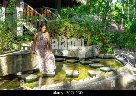 Amerika, Karibik, Großantillen, Dominikanische Republik, Cabarete, Frau genießt die Ruhe in einem Fischteich im Yoga-Bereich des Natura Cabana Boutique Hotel & Spa Stockfoto