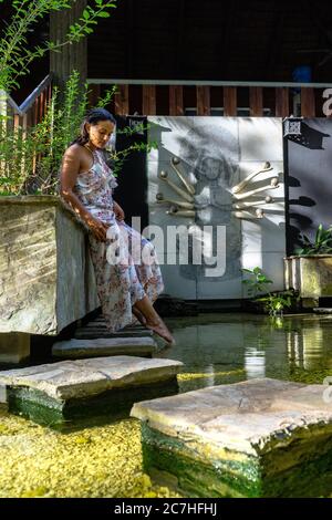 Amerika, Karibik, Großantillen, Dominikanische Republik, Cabarete, Frau genießt die Ruhe in einem Fischteich im Yoga-Bereich des Natura Cabana Boutique Hotel & Spa Stockfoto