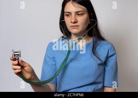 Doktor in blauer Uniform hält ein Stethoskop in der Hand. Stockfoto