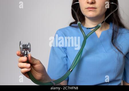 Doktor in blauer Uniform hält ein Stethoskop in der Hand. Stockfoto