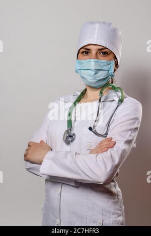 Grünes Stethoskop. Ein Arzt in weißer medizinischer Uniform und Handschuhe hält ein Stethophonendoskop. Stockfoto