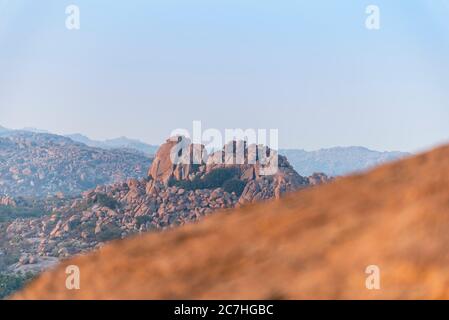 Großer Felsen in der Dämmerung mit Bergkette im Hintergrund Stockfoto