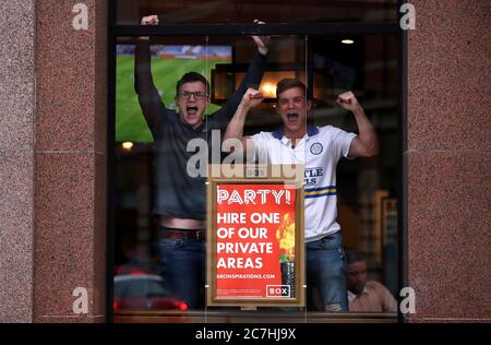 Fans von Leeds United feiern in der Box Bar im Stadtzentrum von Leeds, während sie Huddersfield Town bei einem Spiel, das ihre Beförderung zur Premier League besiegeln könnte, auf West Bromwich Albion auf Sky tv zusehen. Stockfoto