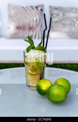 Ein Bild eines frisch zubereiteten Mojito-Cocktails auf einem Tisch mit Limettengarnitur Stockfoto