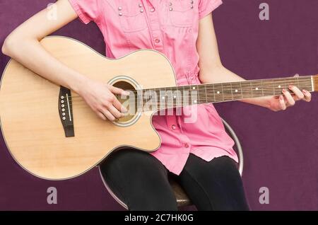 Das Mädchen spielt Gitarre, Hände aus der Nähe. Musikschule Stockfoto