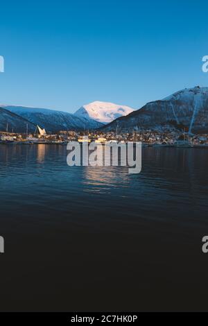 Vertikale Aufnahme des schönen Sees umgeben von schneebedeckten Bergen in Tromso, Norwegen Stockfoto