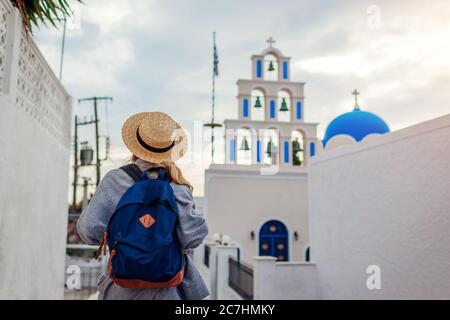 Santorini Tourist mit Rucksack zu Fuß durch die Kirche in Akrotiri auf Santorini. Tourismus, Reisen, Sommerurlaub Stockfoto