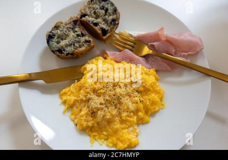 Rührei, Schinken und ein Blaubeer-Muffin Stockfoto