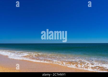 Das azurblaue türkisfarbene Meer mit gelbem Sand aus Muscheln. Stockfoto