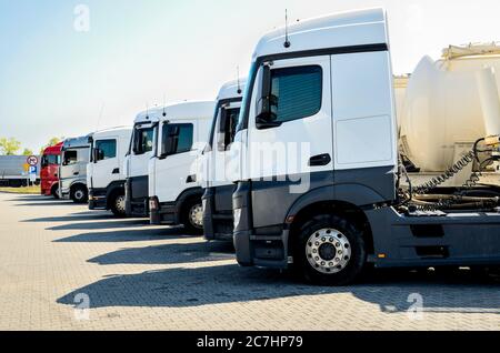 Gruppe von weißen Lastwagen auf dem Parkplatz geparkt. Fahrzeuge in Polen, in der Nähe von Piotrkow Trybunalski Stadt geparkt. Stockfoto