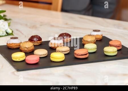 Selektiver Fokus von kleinen Desserts auf einem schwarzen Tablett Stockfoto