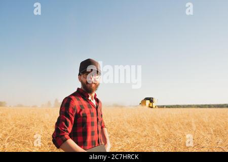 Porträt eines Mannes mit Tablette lin ein Weizen oder Roggen Feld. Moderne Landwirt, Landwirtschaft Business Management, lokale Unternehmer Konzept Stockfoto