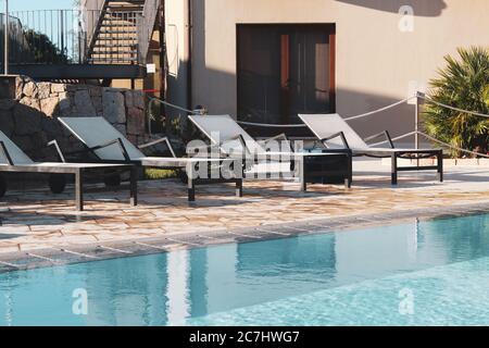 Sonnenliegen in der Nähe des Swimmingpools in einem Resort in San Teodoro, Sardinien Stockfoto