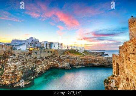 Sonnenuntergang am Cala Paura Golf mit Bastione di Santo Stefano und Lama Monachile Strand im Hintergrund. Polignano a Mare, Apulien, Italien, Provinz Bari. Stockfoto