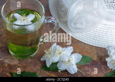 Sommerhut, Jasmintee in einem Becher, Blumen. Stillleben. Hochwertige Fotos Stockfoto
