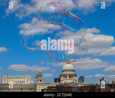 London, Großbritannien, 17. Juli 2020. Die riesigen Seifenblasen eines Künstlers schweben sanft durch die Luft vor dem Hintergrund der St. Paul's Cathedral und des blauen Himmels. Schöner Sonnenschein und warme Temperaturen werden sich bis ins Wochenende fortsetzen. Stockfoto